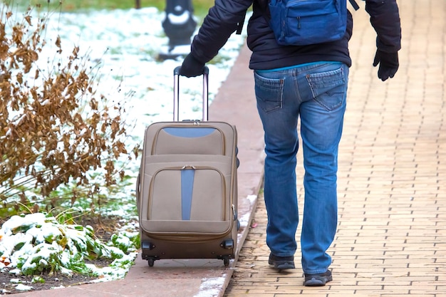 Mężczyzna idący chodnikiem z torbą na bagaż