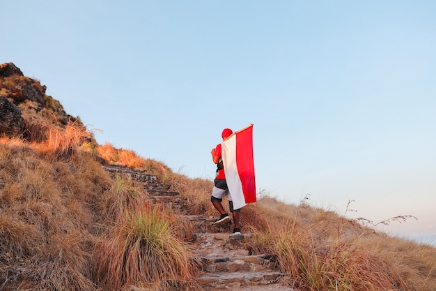 Mężczyzna Idący Na Szczyt Z Niosącą Indonezyjską Flagę