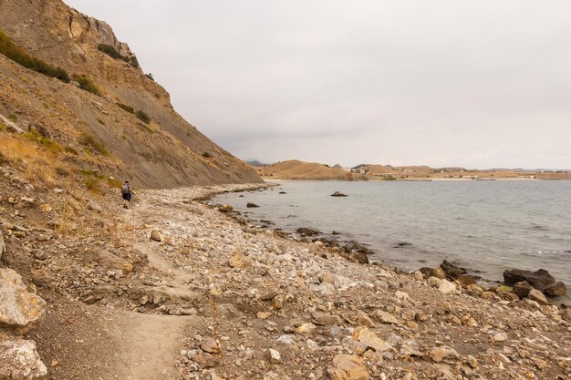 Mężczyzna idzie po kamienistej plaży nad Morzem Czarnym