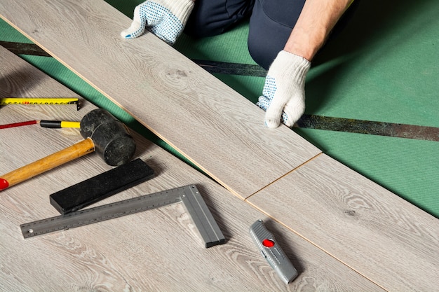 Zdjęcie mężczyzna instaluje nowe podłogi laminowane