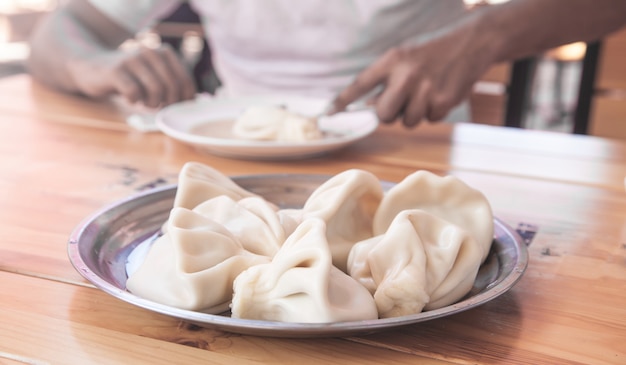 Mężczyzna je chinkali w gruzińskiej restauracji.