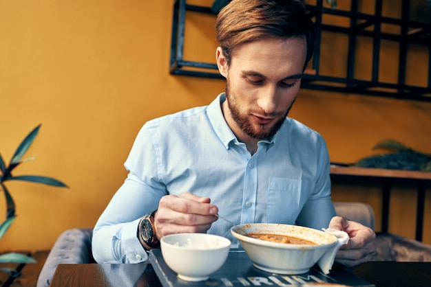 Mężczyzna je przekąskę zupy na lunch w restauracji?