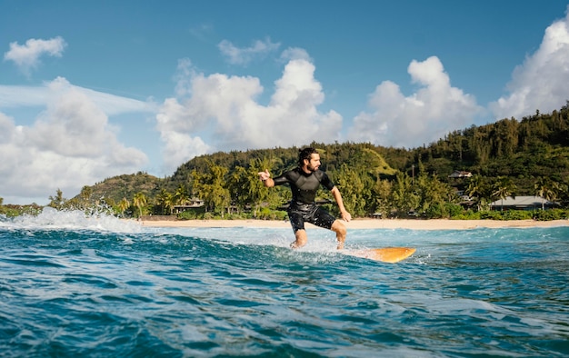 Zdjęcie mężczyzna jedzie na desce surfingowej i miło spędza czas ujęcie poziome