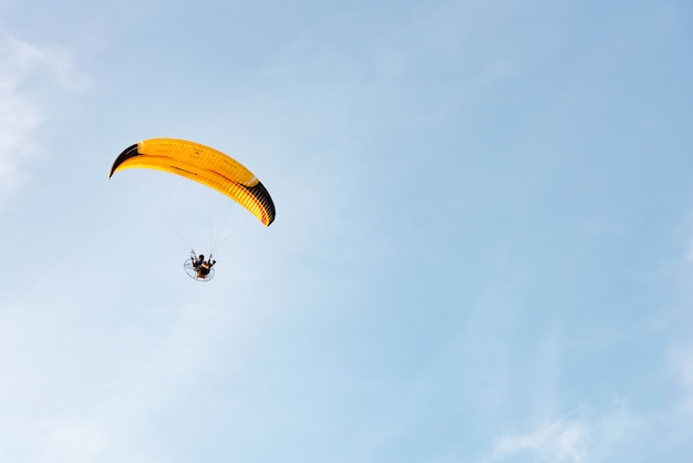 Zdjęcie mężczyzna jedzie paramotor latanie w niebie