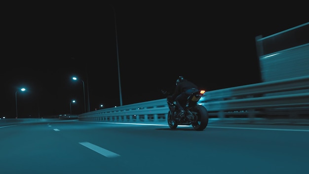 Mężczyzna jeździ motocyklem sportowym na nocnej trasie