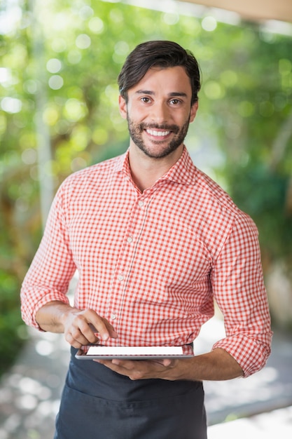 Zdjęcie mężczyzna kelner za pomocą cyfrowego tabletu
