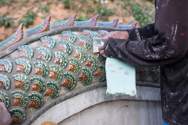 Mężczyzna klejenia płytek ceramicznych na schodach Naga w budowie świątyni Schody Naga w Tajlandii
