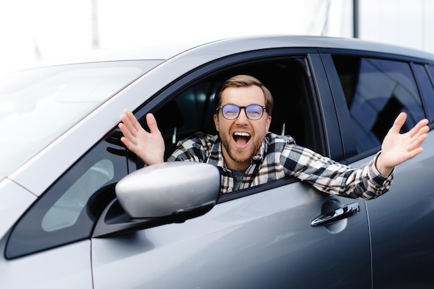 Zdjęcie mężczyzna klient siedzi w salonie samochodowym i uśmiecha się, wybierając auto i chcąc kupić nowy samochód w salonie dealerskim koncepcja sprzedaży samochodów