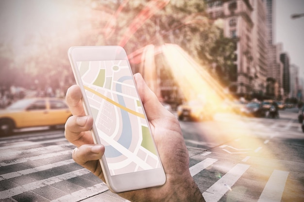 Mężczyzna korzystający z aplikacji mapy na telefonie przed ulicą Nowego Jorku