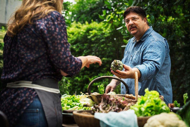 Mężczyzna kupuje świeżego organicznie warzywa przy rynkiem