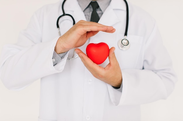 Mężczyzna lekarz kardiolog trzymający serce na białym tle