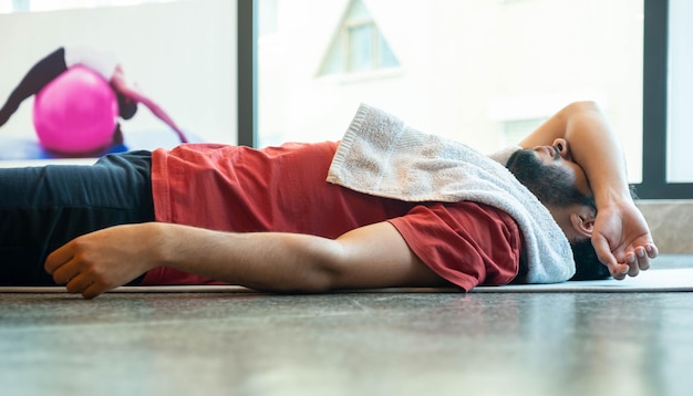 Mężczyzna leżący na podłodze podczas odpoczynku na podłodze GYM