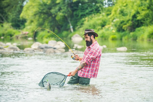 Mężczyzna łowi Ryby I Relaksuje Się, Ciesząc Się Hobby Ryba Na Haczyku Rybak I Pstrąg Letnie Wakacje I Koncepcja Ludzi Brodaty Rybak Retro I Pstrąg Trofeum