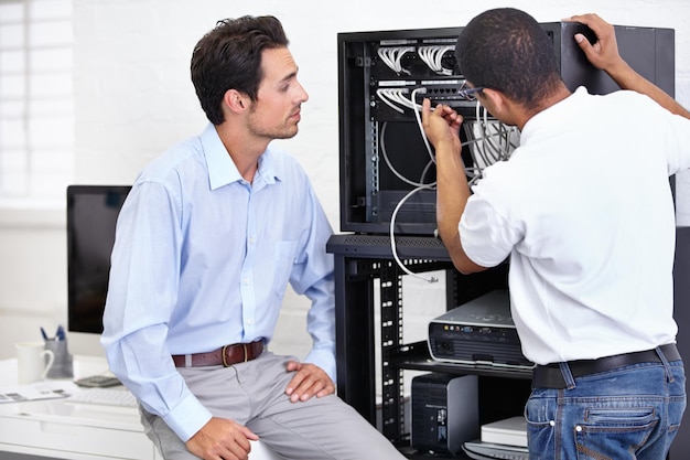 Mężczyzna lub technik serwerowni pracujący nad konserwacją sprzętu po usterce w biurze biznesowym Wsparcie techniczne sieci lub pracownik z elektrykiem lub inżynierem elektrykiem ds. Informatyki
