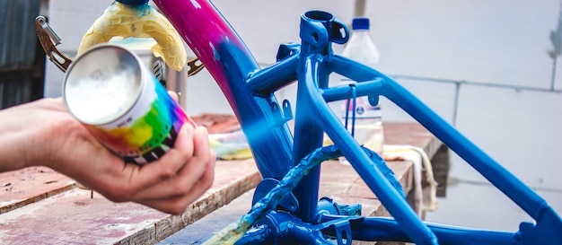 Mężczyzna maluje rower farbą w sprayu