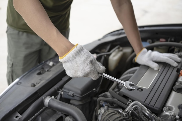 Zdjęcie mężczyzna mechanik samochodowy naprawianie silnika samochodu.