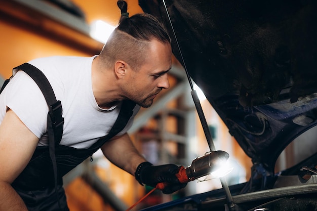 Mężczyzna mechanik w pobliżu samochodu w centrum serwisowym