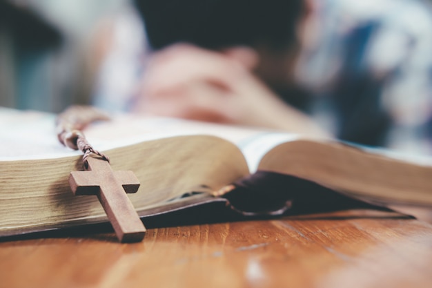 Mężczyzna modlił się, ręce splecione razem na jej Biblii.