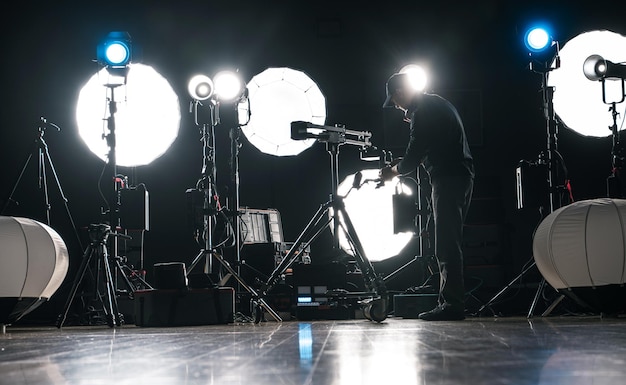 Zdjęcie mężczyzna montujący potężne nowoczesne oświetlenie wideo i fotograficzne led