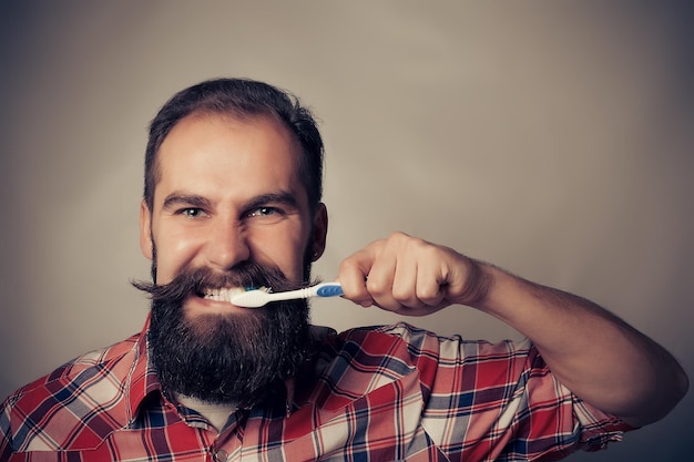 Mężczyzna myje zęby przed portretem w lustrze