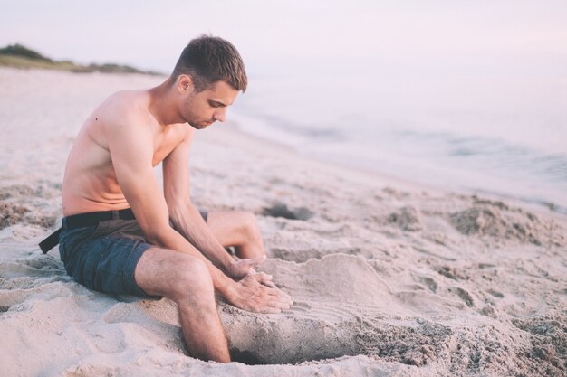 Mężczyzna na plażowym budynku piaska kasztelu