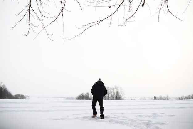 Mężczyzna na spacerze. Zimowy krajobraz. Turysta w zimowej podróży.
