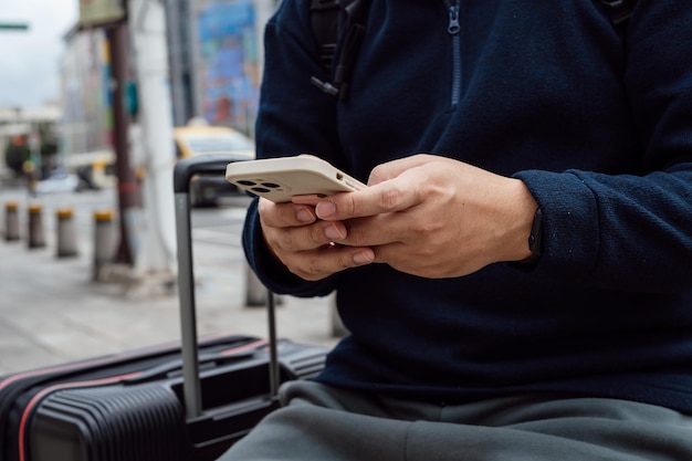 Mężczyzna na ulicy w centrum miasta zamawiający taksówkę za pomocą aplikacji na smartfona Rezerwacja taksówki za pomocą aplikacji online na smartfonie