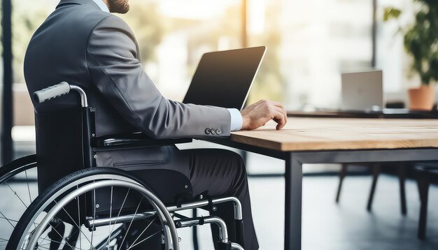 Mężczyzna na wózku inwalidzkim pracuje na laptopie