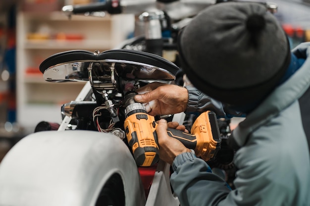 Zdjęcie mężczyzna naprawiający motocykl w nowoczesnym warsztacie