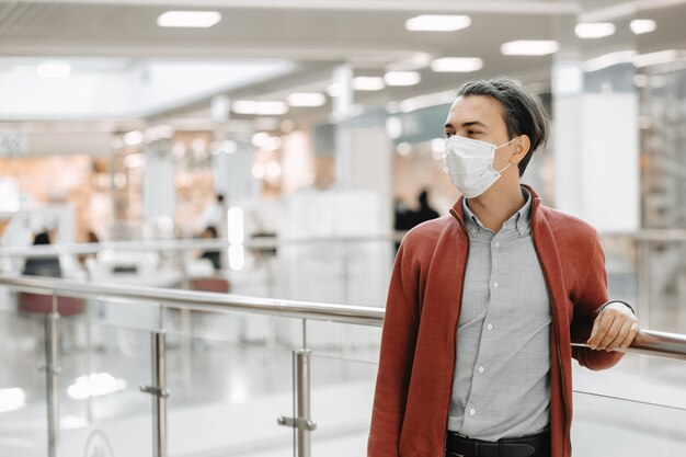 Mężczyzna nosi maskę medyczną przeciwko koronawirusowi podczas zakupów w supermarkecie
