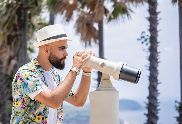 Mężczyzna obserwujący przez teleskop lornetkowy stojący na punkcie obserwacyjnym