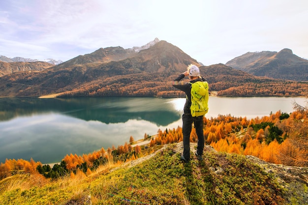 Mężczyzna obserwuje jesienny krajobraz nad górskim jeziorem