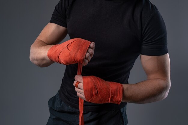 Mężczyzna owijający ręce biurokracją przygotowujący się do boksu