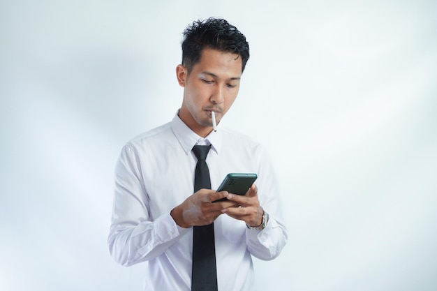 Zdjęcie mężczyzna palący papierosa i korzystający ze smartfona