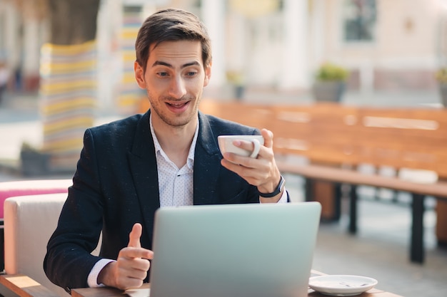 Mężczyzna patrzeje zaskakujący laptop i pokazuje