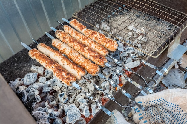 Mężczyzna piecze kebaba na węglach na grillu Piknik na świeżym powietrzu
