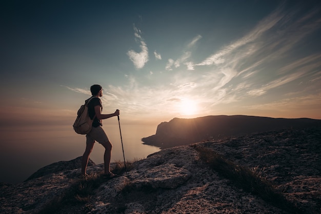 Zdjęcie mężczyzna piesze wycieczki w góry zachód słońca z ciężkim plecakiem. podróży styl życia wanderlust przygoda koncepcja letnie wakacje na zewnątrz sam na dziko, makieta tekstu.