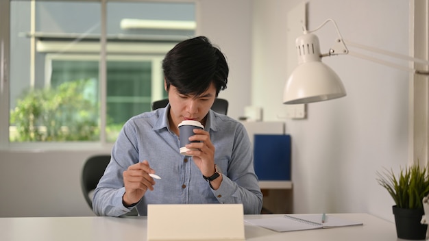 Mężczyzna pijący kawę i pracujący w biurze