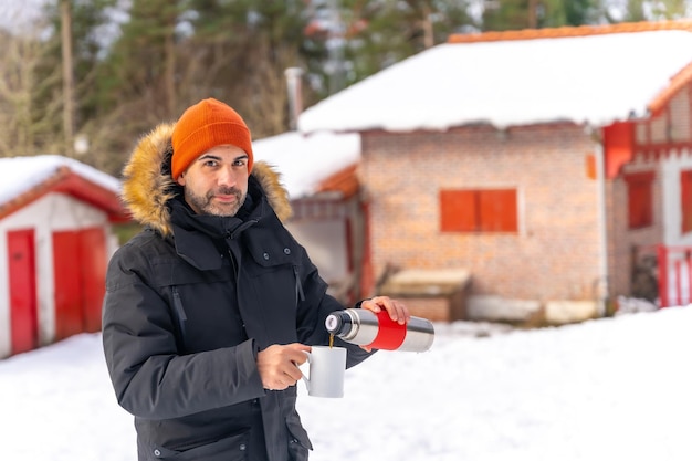 Mężczyzna Pijący Kawę Z Gorącego Termosu Zimą Na śniegu