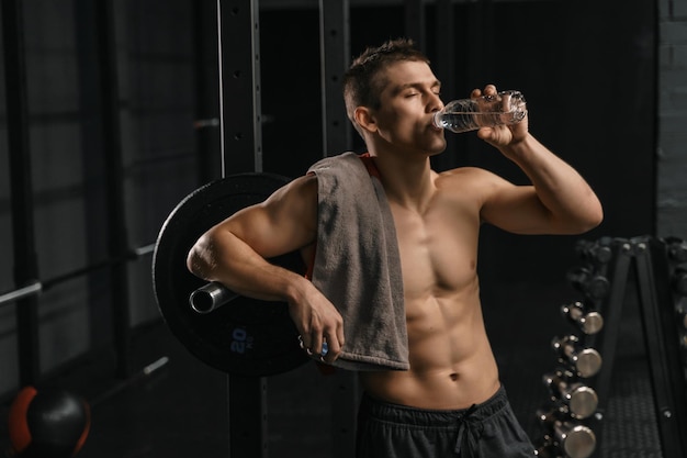 Mężczyzna pije wodę po ciężkim treningu