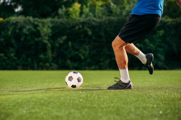 Mężczyzna Piłkarz Uderza Piłkę Na Boisku. Piłkarz Na Stadionie Zewnętrznym, Trening Przed Meczem, Trening Piłkarski