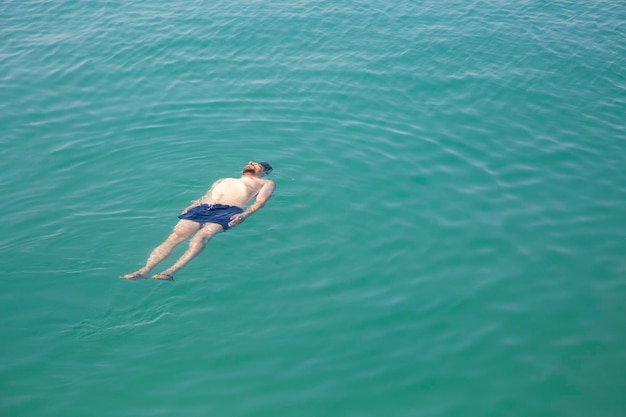 Mężczyzna pływający w morzu, widok z góry.