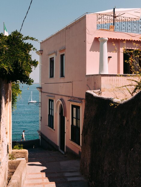 Zdjęcie mężczyzna po drugiej stronie ulicy capri przy morzu