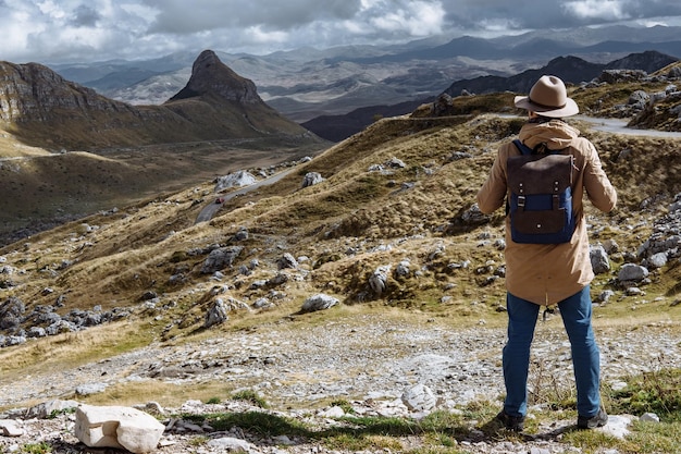 Mężczyzna Podróżnik W Kapeluszu I Plecaku Patrzący Na Szczyt Wzgórza Durmitor Montenegro