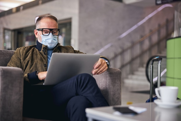 Mężczyzna Podróżny Pracujący Na Laptopie W Salonie