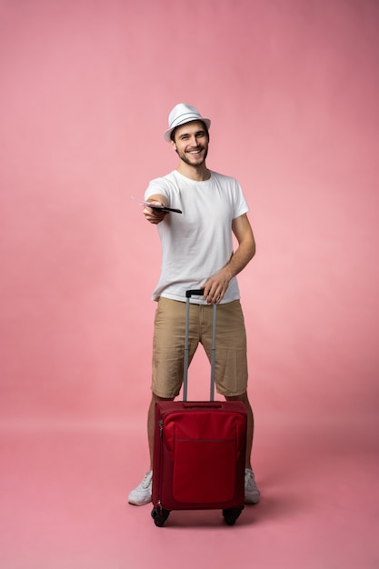 Mężczyzna podróżujący z walizką, paszportem i biletem.