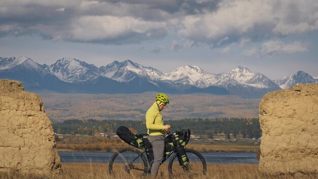 Mężczyzna podróżuje po mieszanym terenie cykloturystyka z bikepackingiem Podróżnik podróżuje z torbami rowerowymi Turystyka sportowa bikepacking