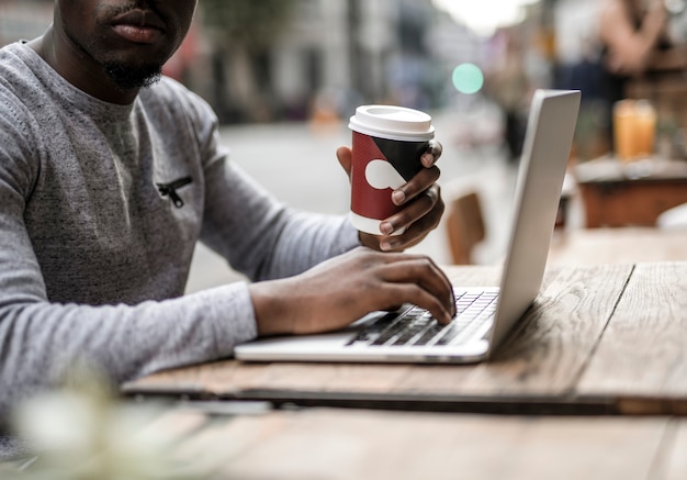 Mężczyzna pracujący na laptopie w kawiarni