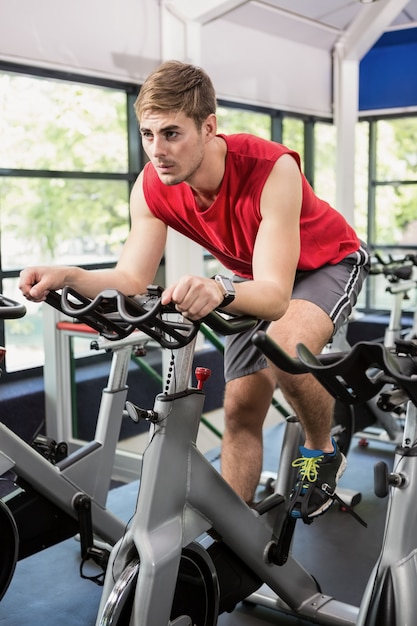 Mężczyzna pracujący na rowerze stacjonarnym w spinning klasy