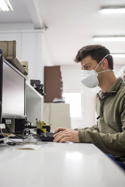 Mężczyzna pracujący na stole z maską